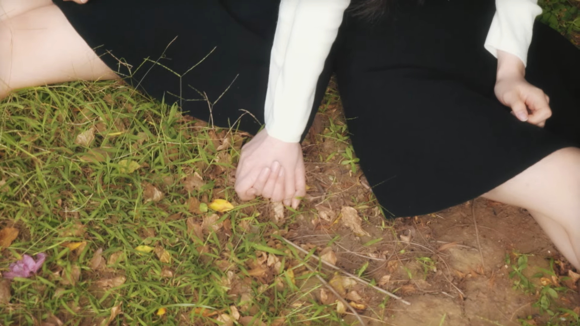 Heejin and Hyunjin sitting and holding hands.